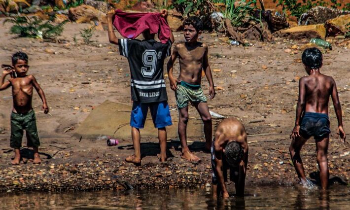 Crianças brincam no Rio Anhanduí, região periférica de Campo Grande (MS). 