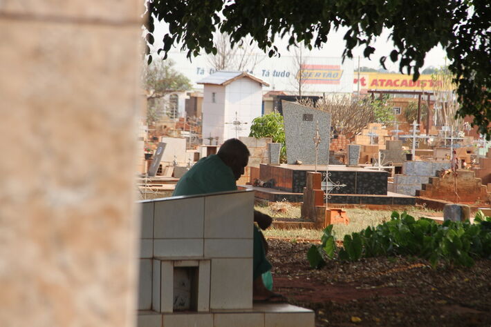 Homem triste em um cemitério na Capital de MS