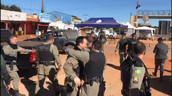 Policiais comemorando após jogarem Lázaro já morto em ambulância