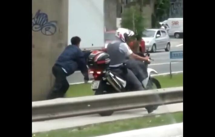 Um vídeo de um homem algemado atrás de uma moto de um policial militar em São Paulo. Foto: Print da tela