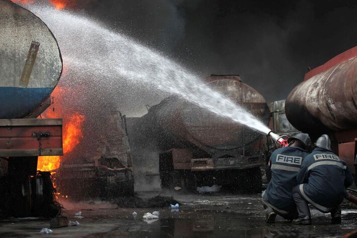 Bombeiros tentam apagar um incêndio no local de uma explosão depois que caminhões-tanque pegaram fogo em uma garagem de caminhões comerciais no distrito de Apapa, na capital comercial de Lagos, na Nigéria. REUTERS/Akintunde Akinleye