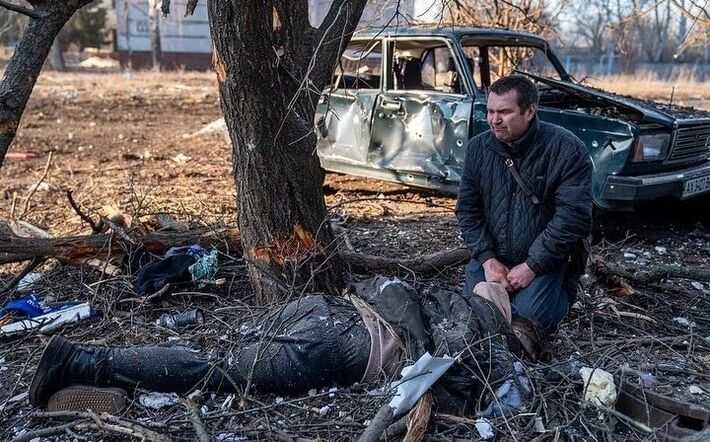 Homem chora ao lado de corpo de ente querido abatido na guerra na Ucrânia. Foto: Redes 