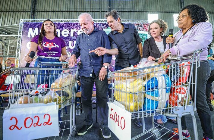 Lula observa carrinhos com alimentos comprados por R$100,00 em 2010 e em 2022. Janja, Gleisi Hoffmann e Fernando Haddad participaram do encontro. Foto: Ricardo Stuckert