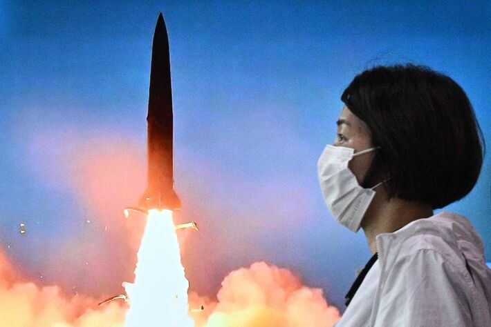 Mulher passa em frente a uma tela de TV em Seul, na Coreia do Sul, que mostra o lançamento de mísseis realizado pela vizinha Coreia do Norte - Anthony Wallace - 5.jun.22/AFP