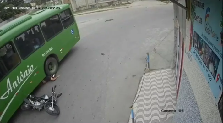 Motoqueiro cai e vai parar embaixo da roda de um ônibus no RJ  Foto: Reprodução