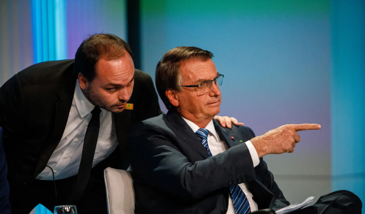 Jair Bolsonaro e seu filho, Carlos Bolsonaro durante debate da TV Globo na noite da quinta (29.set.22). Foto: AFP | TV Globo