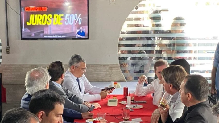 O presidente Jair Bolsonaro (PL), acompanhado de ministros, em restaurante na Vila Planalto, no Distrito Federal; No momento, assiste ao programa eleitoral de Lula. Créditos: Sérgio Lima | Poder360