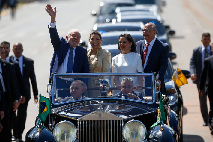 O presidente Lula, acompanhado da 1ª dama Janja, acenam para o público durante o desfile em carro aberto da posse, que se iniciou na Catedral Metropolitana no DF e foi até o Congresso Nacional. (Pedro Ladeira/Folhapress, PODER) 