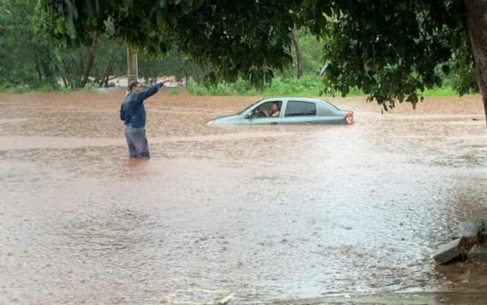 Homem se informa em meio a enchente na Avenida Ernesto Geisel, esquina com a Campeste, em Campo Grande. Foto: Redes 