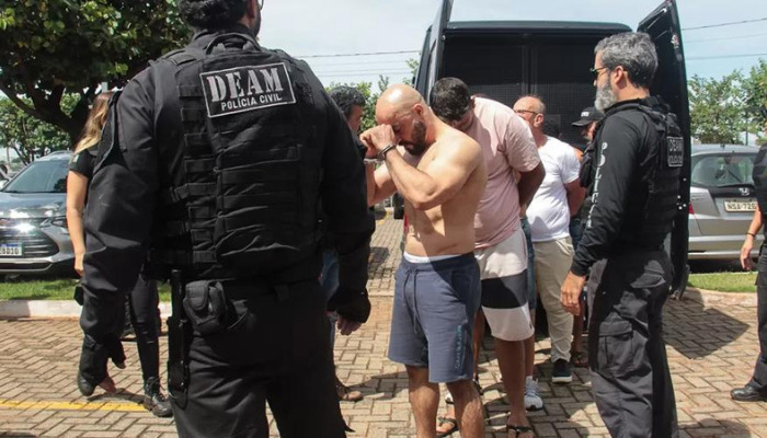 Nour está careca e leva a mão ao rosto; grupo de presos foi conduzido a cela da 1ª-Deam - (Foto: Luciano Muta do Diário Digital)