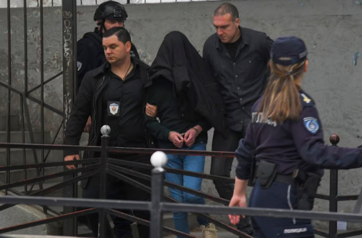 O autor é escoltado pela polícia do lado de fora da escola Vladislav Ribnikar em Belgrado, Sérvia, quarta-feira, 3 de maio de 2023. Foto: AFP
