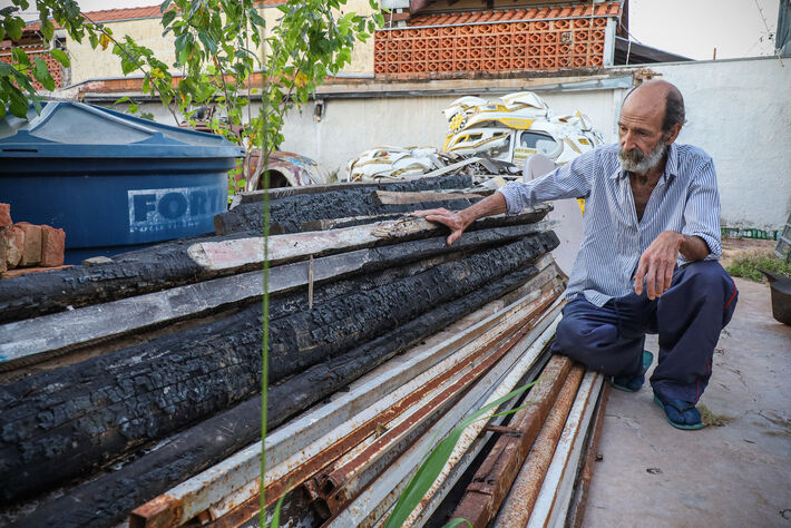 (5.ago.23) - Celso Aristimunho mostra madeira da antiga casa destruída por incêndio. Foto: Henrique Kawaminami