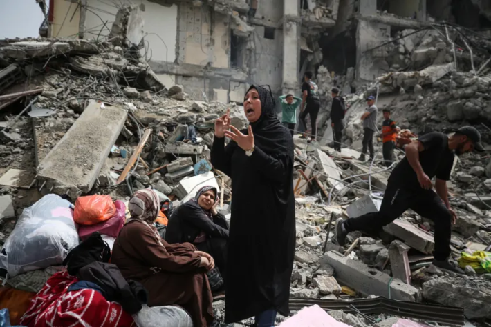 Mulheres palestinas sentam-se nos escombros de um prédio residencial destruído por um ataque israelense em Nuseirat, no centro de Gaza, em 18 de abril [Majdi Fathi/NurPhoto via Getty Images]