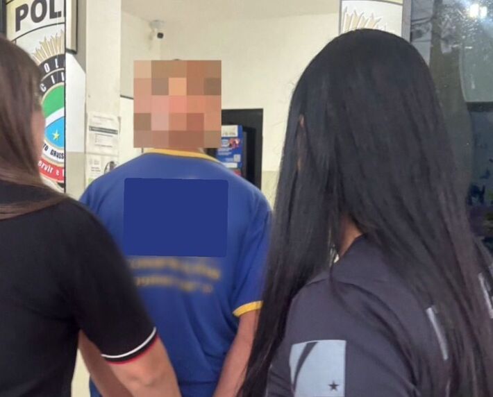 Homem sendo conduzido por policiais após prisão