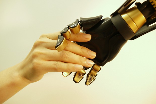 Mão humana aperta mão robótica com mecanorreceptores artificiais (Foto: Bao Research Group/Stanford University)