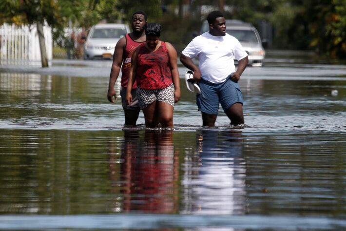 Pessoas caminham em uma rua inundada após passagem do furacão Irma, em Norh Miami, na Flórida