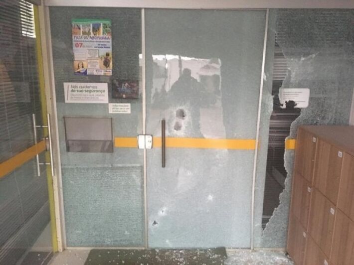 Porta de vidro da agência do Sicredi em Coronel Sapucaia, arrebentada a tiros durante assalto
