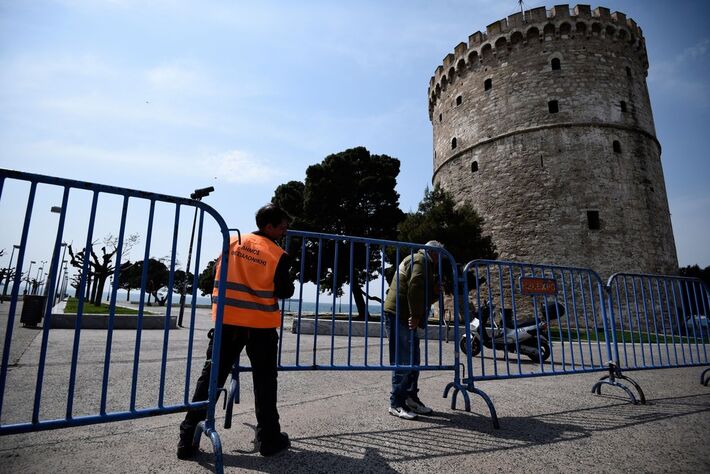 Funcionários da prefeitura instalam cerca como medida de isolamento para contribuir com o controle da propagação do novo coronavírus em frente à Torre Branca, o principal marco na cidade de Thessaloniki, na Grécia, nesta terça-feira (31)