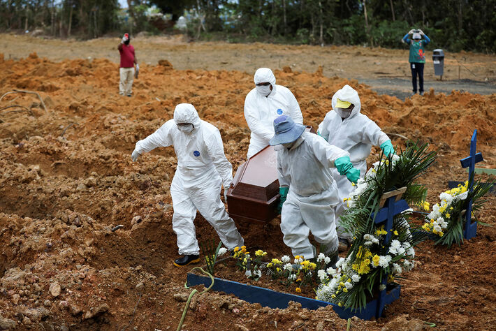 Coveiros vestindo roupas de proteção se preparam para enterrar Lelito Jose Martins, 78 anos, falecido devido à doença por coronavírus, no cemitério Parque Taruma, em Manaus