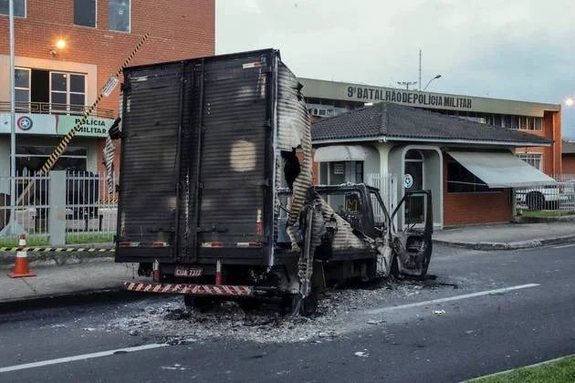 Carro incendiado em frente ao batalhão de polícia da cidade. Foto: Reprodução/Twitter 