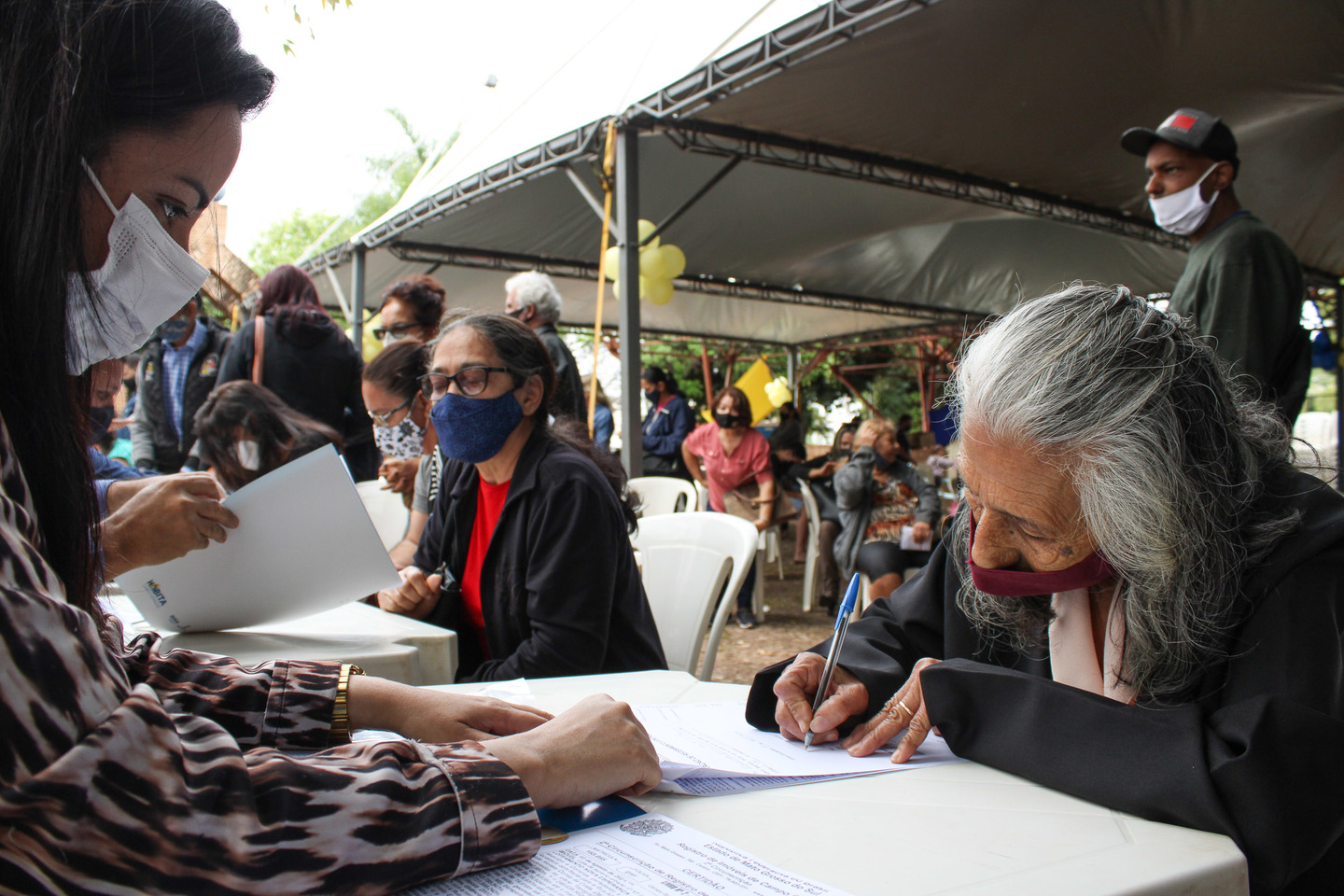 Presentes assinam papeladas de moradia e lotes a que foram sorteados. Foto: Diogo Gon&ccedil;alves 