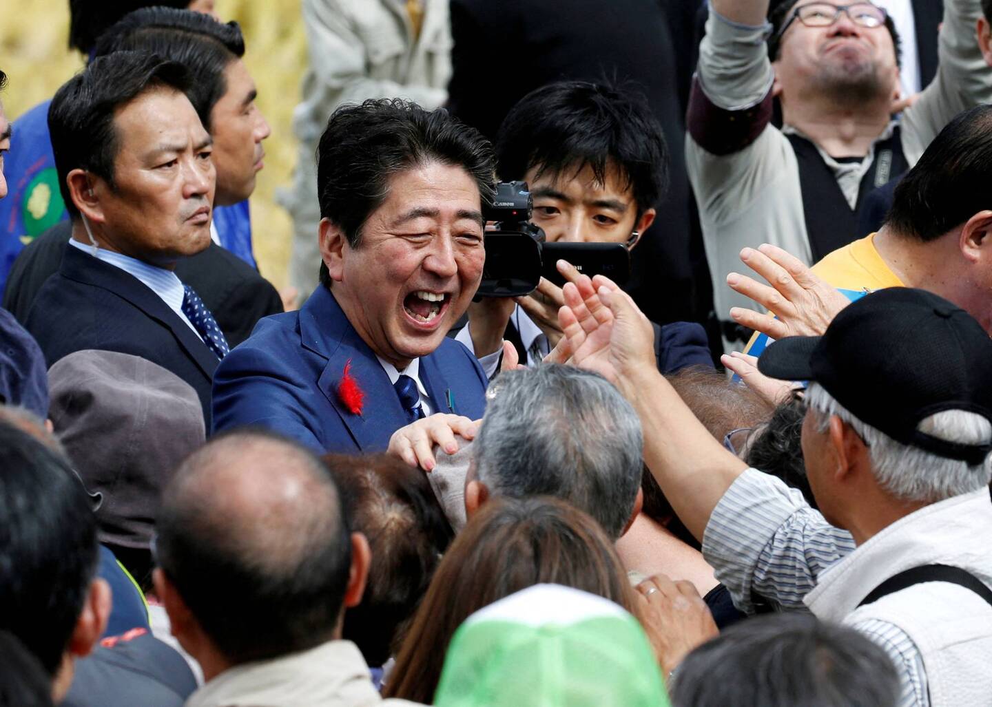 Abe aperta a mão de apoiadores após um comício de campanha eleitoral da Câmara dos Deputados em Fukushima em outubro de 2017. | REUTERS