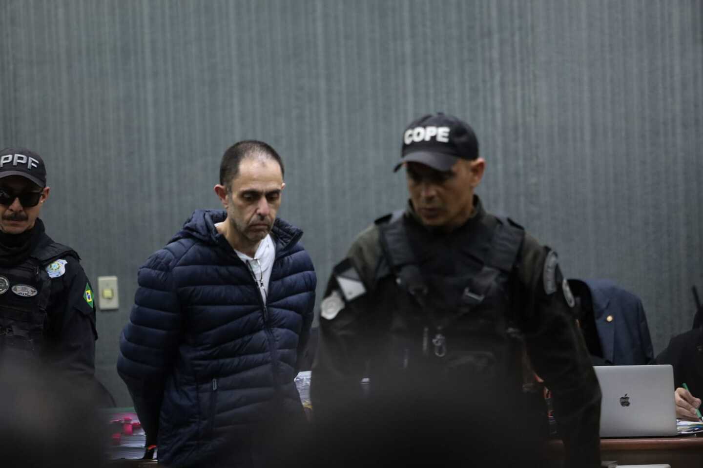 Jamilzinho sendo conduzido a cadeira de r&eacute;us no F&oacute;rum de Campo Grande. Foto: MS Not&iacute;cias