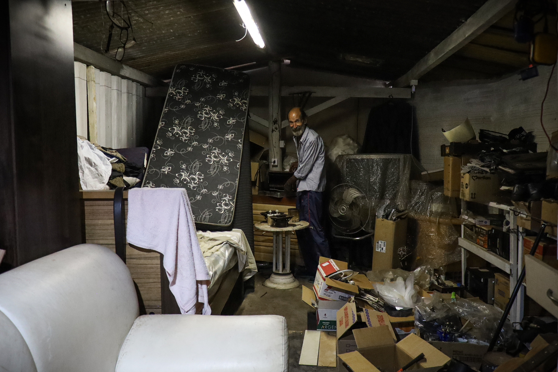 (5.jul.23) - Cama de Celso est&aacute; entre objetos de reciclagem em cobertura improvisada. Foto: Henrique Kawaminami