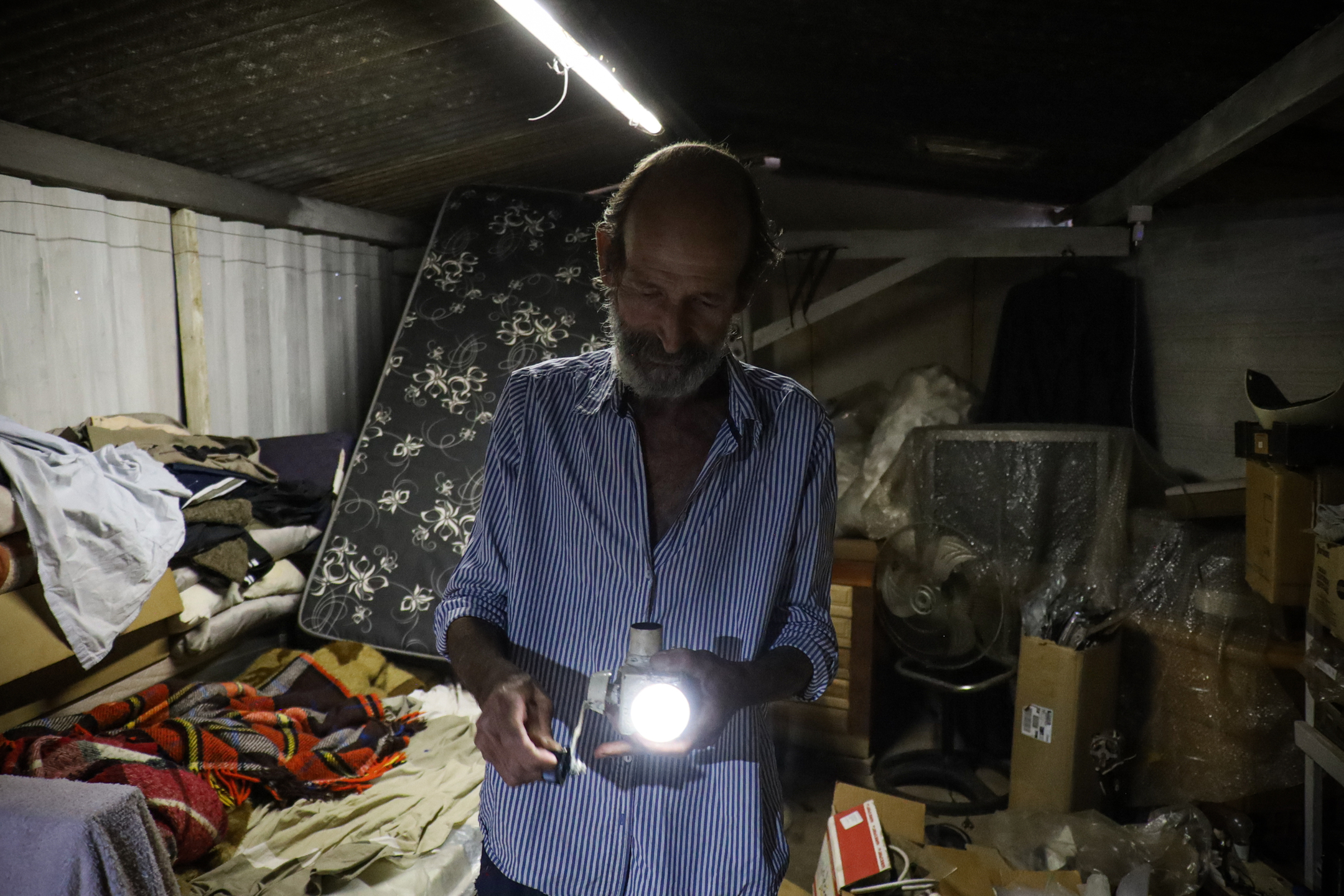 (5.jul.23) - Celso monstra uma lanterna a manivela que ele construiu com uso de recicl&aacute;veis. Foto: Henrique Kawaminami