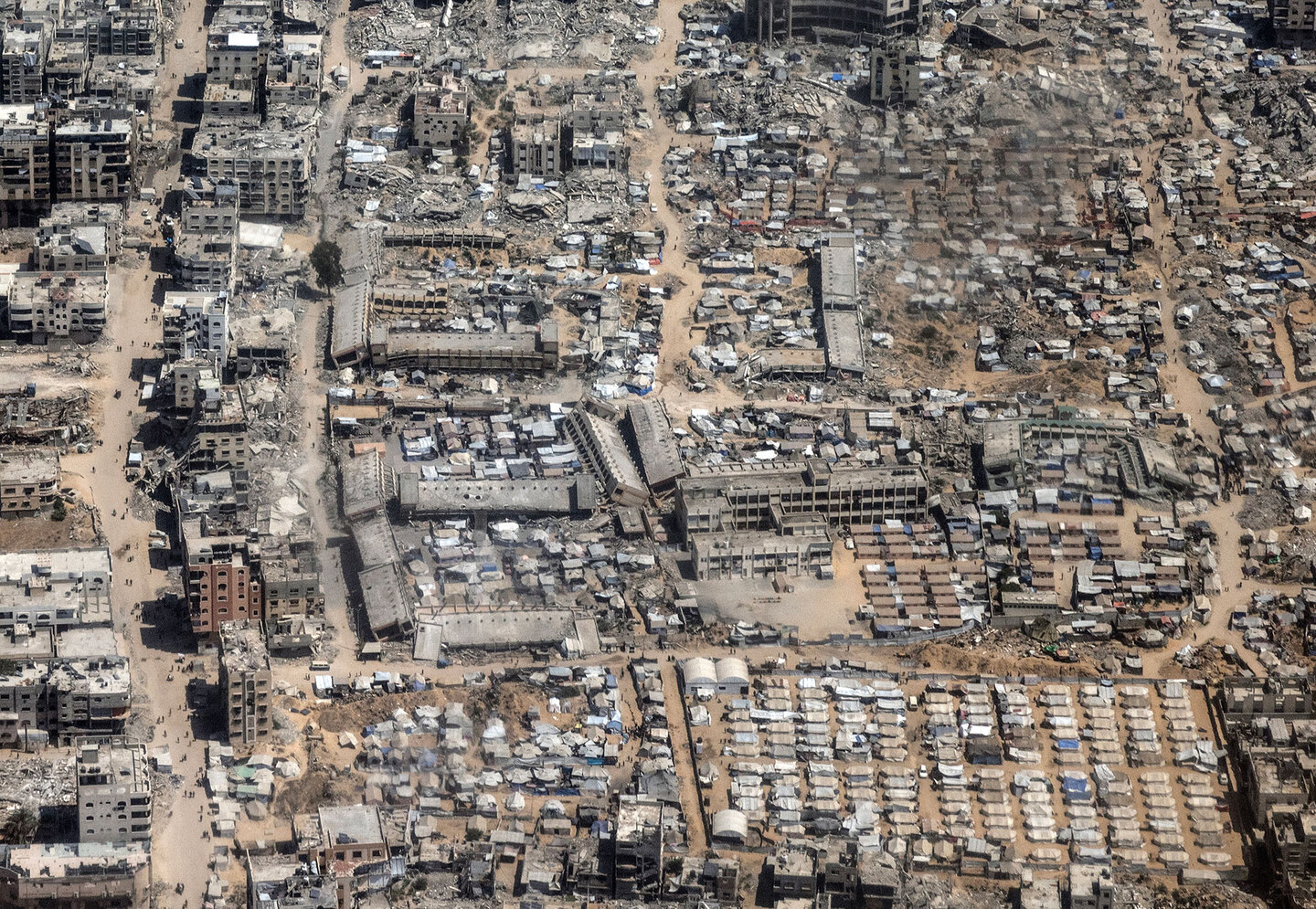 Foto de Heidi Levine (30 de julho de 2025) mostrando uma vista aérea da destruição de Gaza, tirada durante um voo militar da Royal Jordanian para uma missão de ajuda humanitária.
